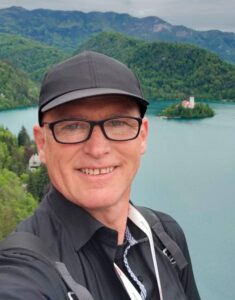 Portrait of tour guide Tomaž Rant with Lake Bled and Bled Island in the background, Slovenia